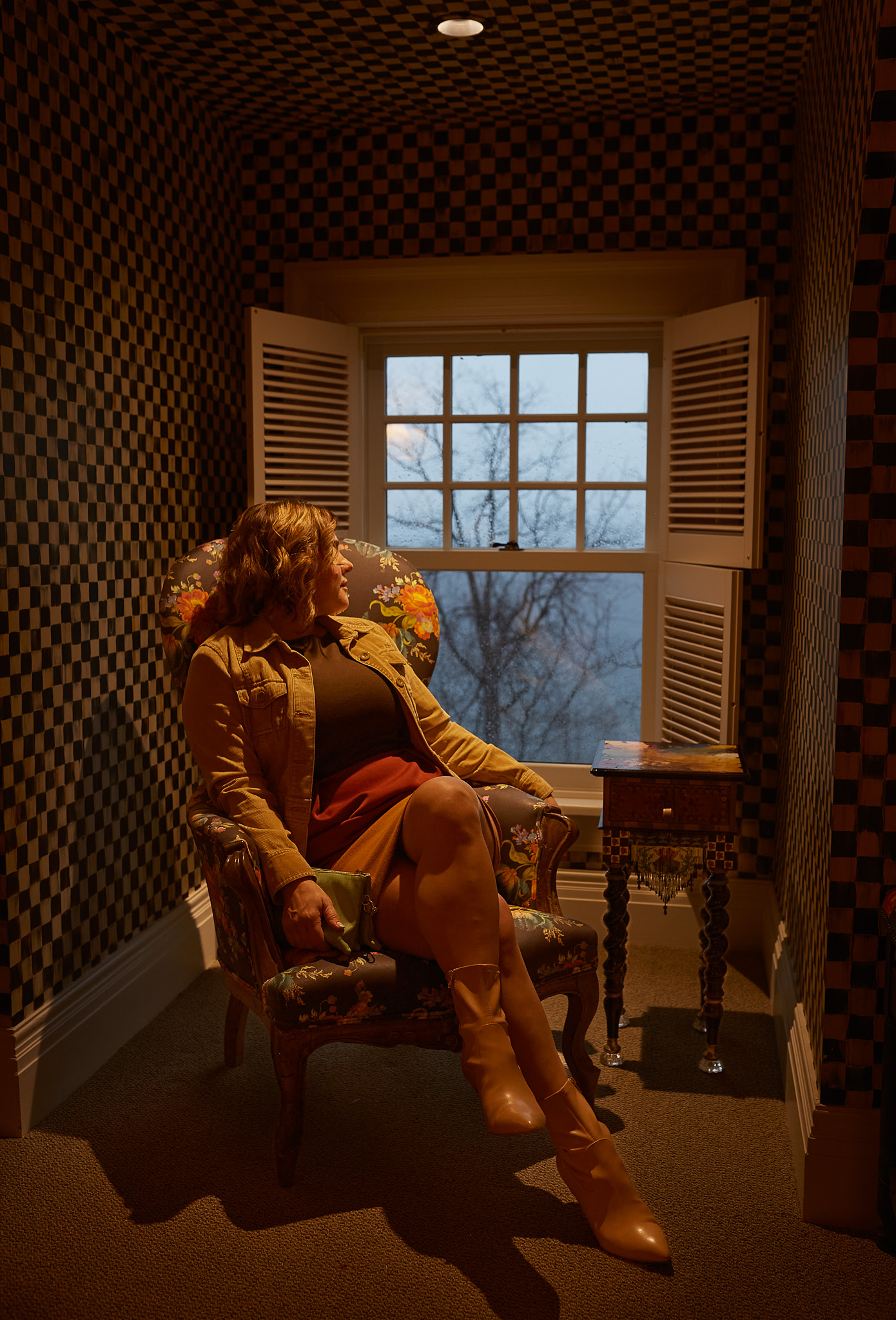 Person sitting in a patterned room.