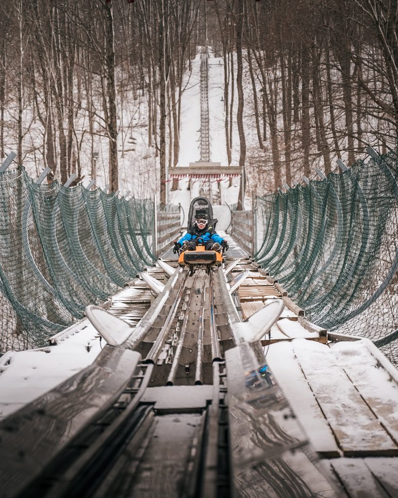 Ithaca Cortland Winter Getaway Mountain coaster track in snowy forest.