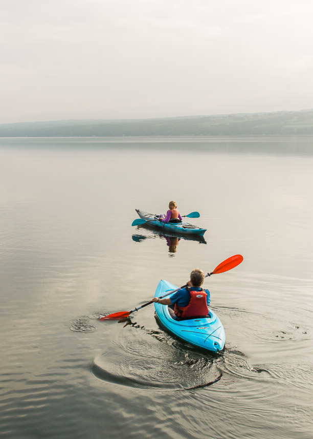 a couple of people in kayaks on a lake